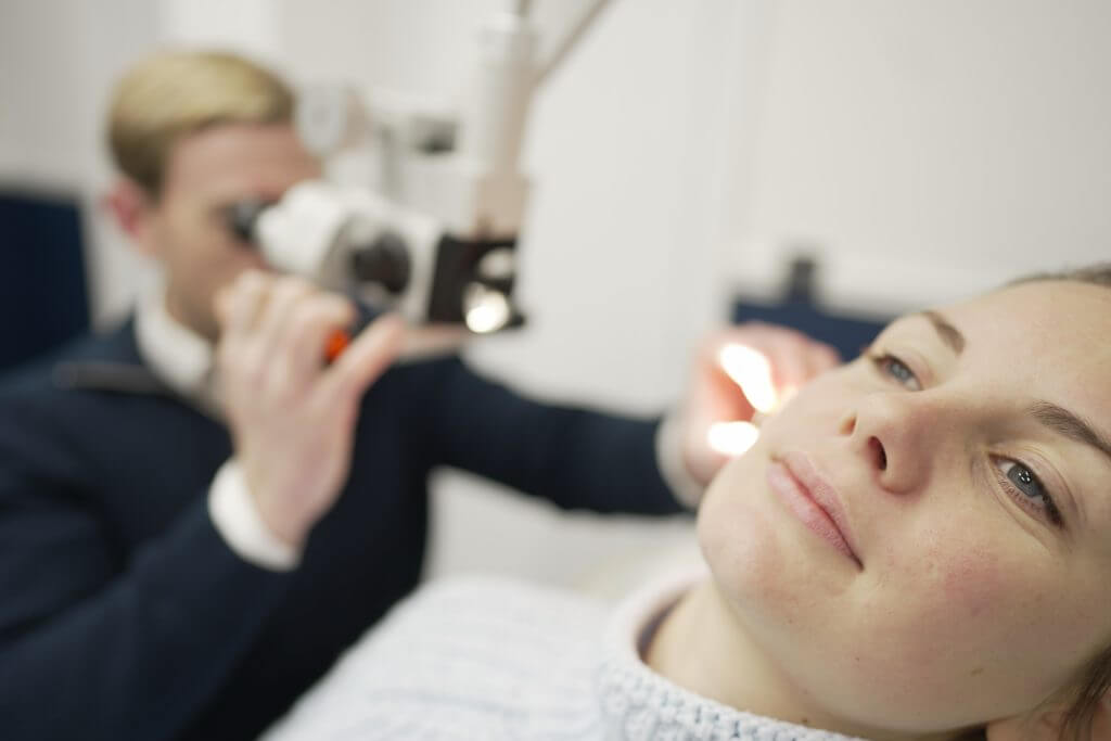 patient having ear inspected with light