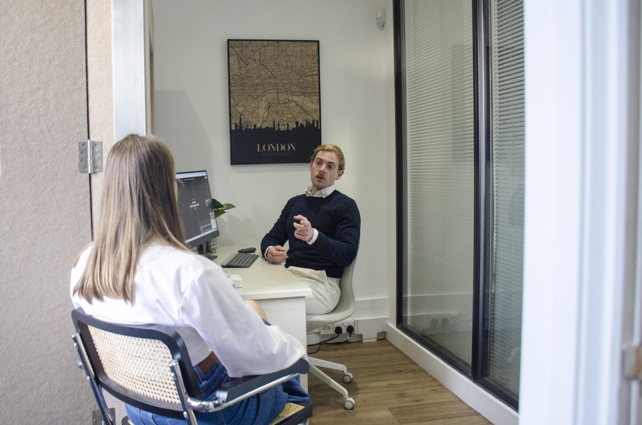 Dylan in his office chatting to patient